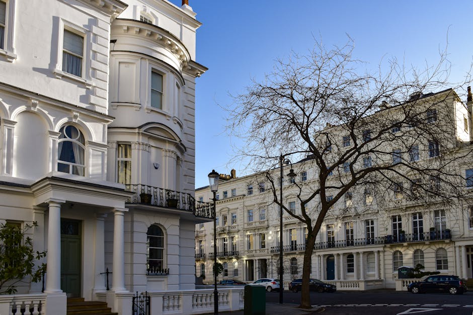 A detailed, upward-looking view of a historic, multi-storey residential building with cream-colored facades and decorative architectural elements, including ornate window frames and cornices, situated